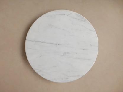 Marble-topped Jorah Martini Table with a round white surface; gold base visible below, close-up angle.