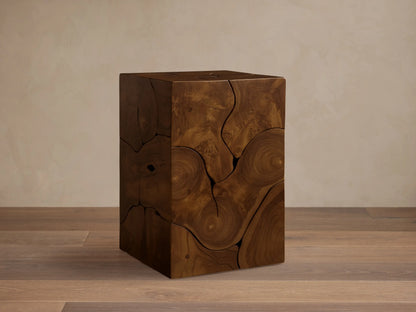 Kalmar Pedestal in natural teak wood featuring organic cracks, knots, and swirling patterns on a smooth, cube-shaped design.