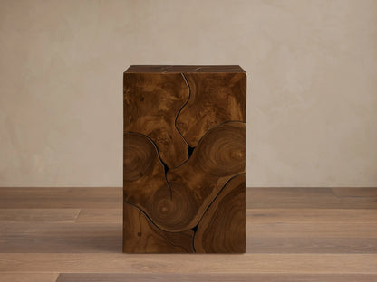 Kalmar Pedestal in natural teak wood featuring organic cracks, knots, and swirling patterns on a smooth, cube-shaped design.