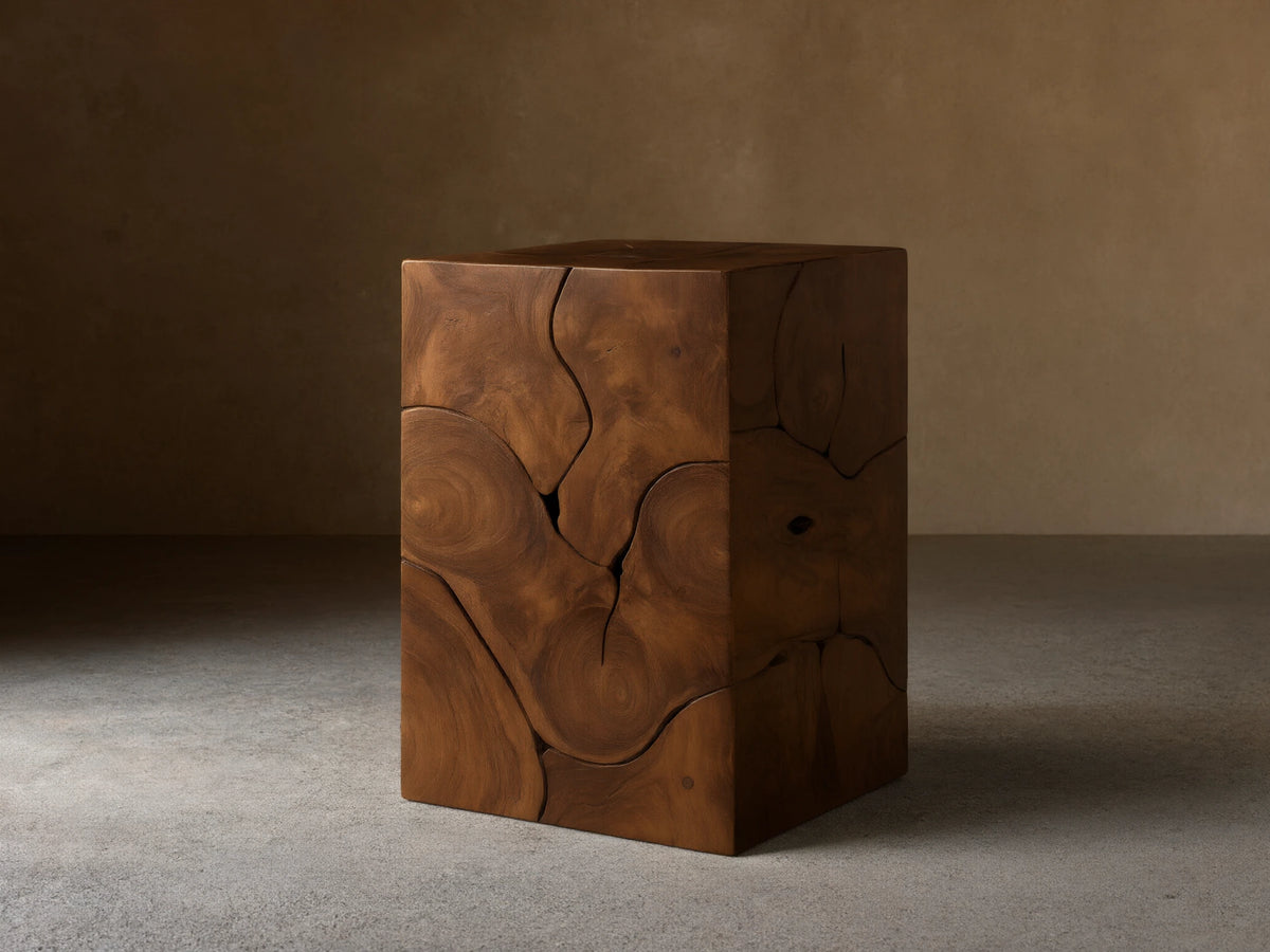 Kalmar Pedestal in natural teak wood featuring organic cracks, knots, and swirling patterns on a smooth, cube-shaped design.