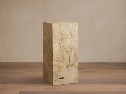 Kalmar Pedestal made of natural teak wood with visible organic shapes, cracks, and patinas, on a wooden floor.
