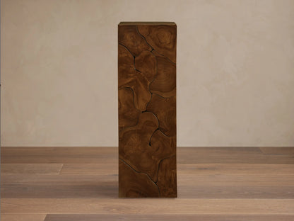 Kalmar Pedestal made from teak wood with visible organic cracks and patterns. It has a tall, rectangular shape with rich wood tones.