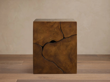 Kalmar End Table made of natural teak wood, showing organic shapes, cracks, and unique grain patterns, set against a light wall.