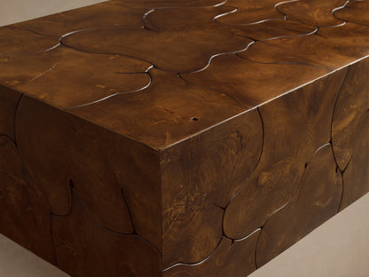 Kalmar Coffee Table made of natural teak wood with visible organic shapes, cracks, and a rich brown patina, on wooden floor.
