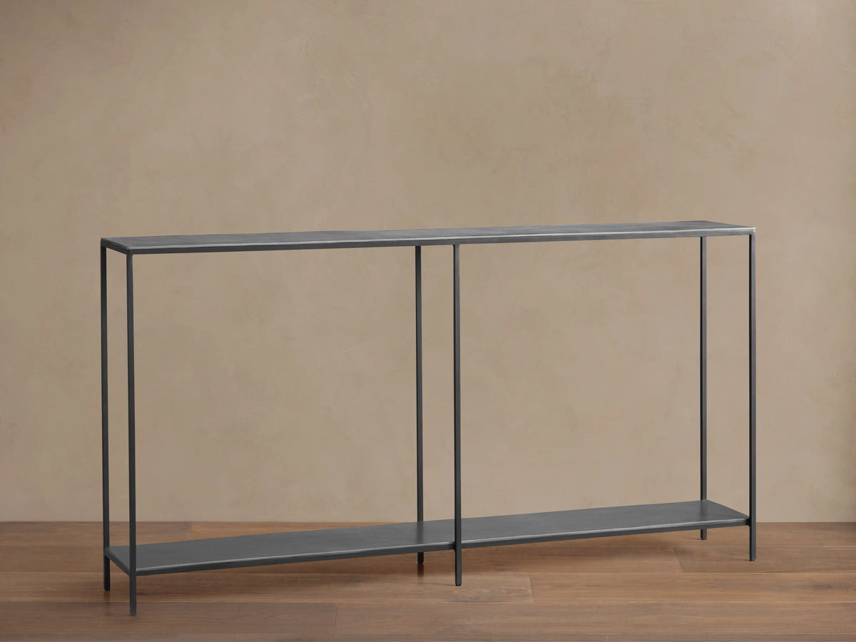 Kavali Console Table with slim black iron frame, powder-coated finish, and rectangular shape on a wooden floor.