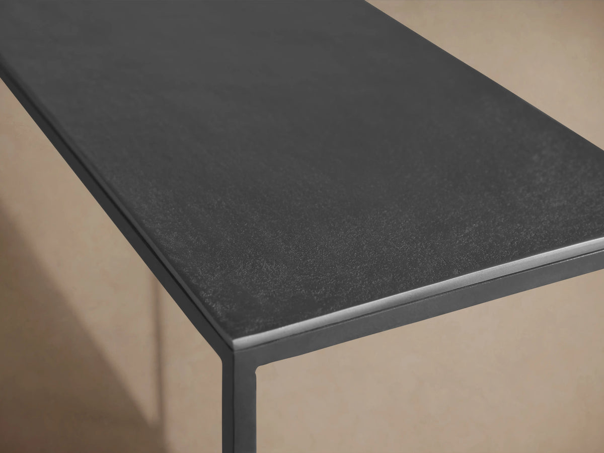 Kavali Console Table with a sleek black powder-coated finish on solid iron, featuring a minimalist rectangular surface.