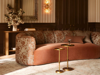 Kenneth Martini Table: Tall, hand-antiqued polished gold cast aluminum with round top, slender stem, and round base. On stone floor.