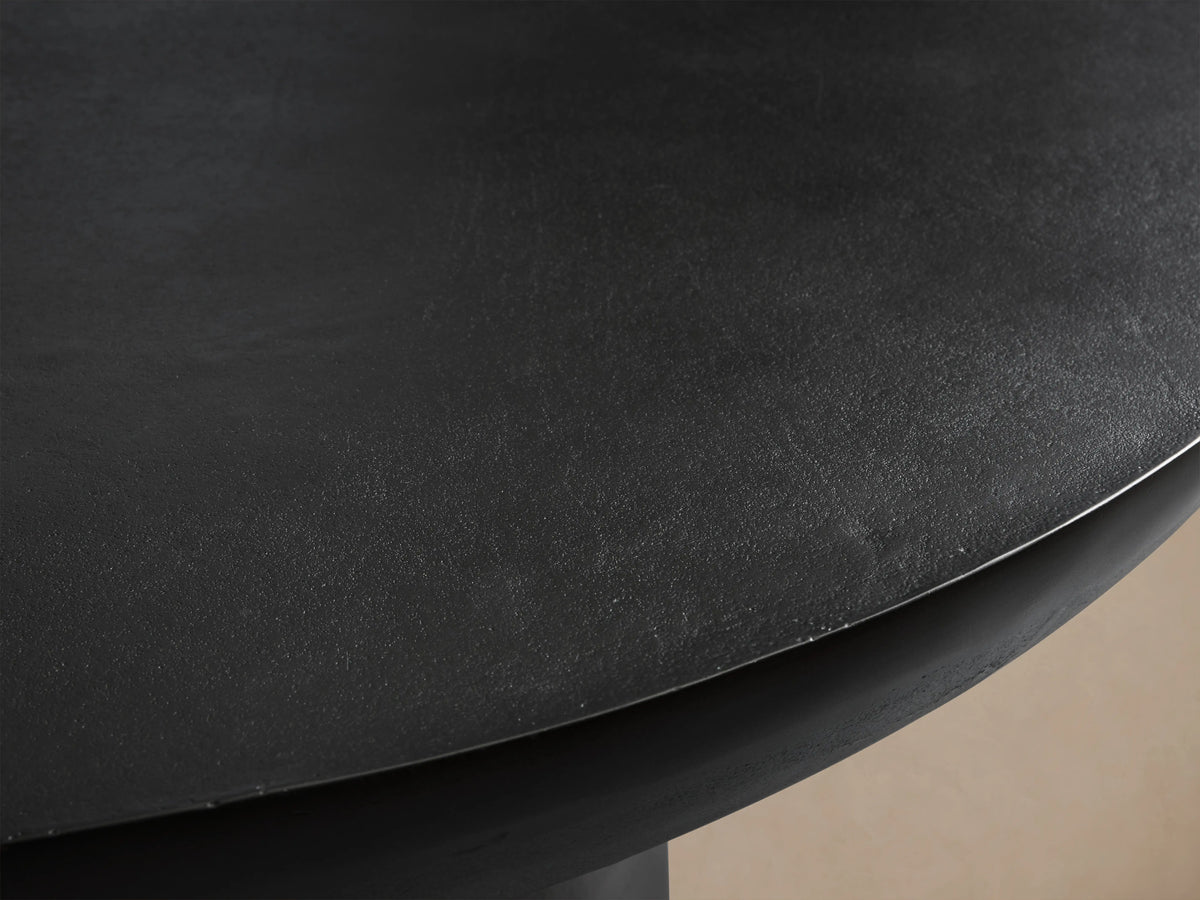 Kyoto Round Coffee Table with a smooth, dark surface texture, showcasing its aluminum material and rounded edge.