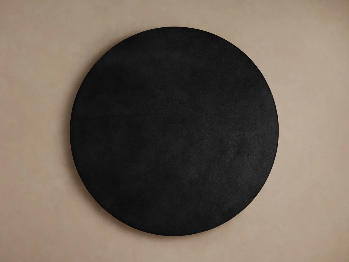 Kyoto Round Coffee Table with a sleek, dark aluminum surface. Close-up of the rounded edge, showing smooth finish and subtle sheen.