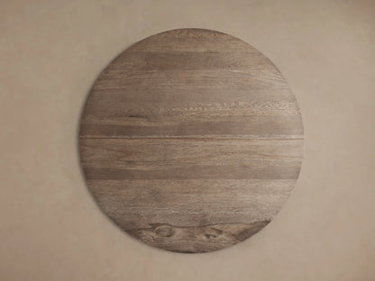 Round coffee table made of reclaimed oak with visible grain patterns and organic textures. The surface has a sun-bleached spalted oak finish.
