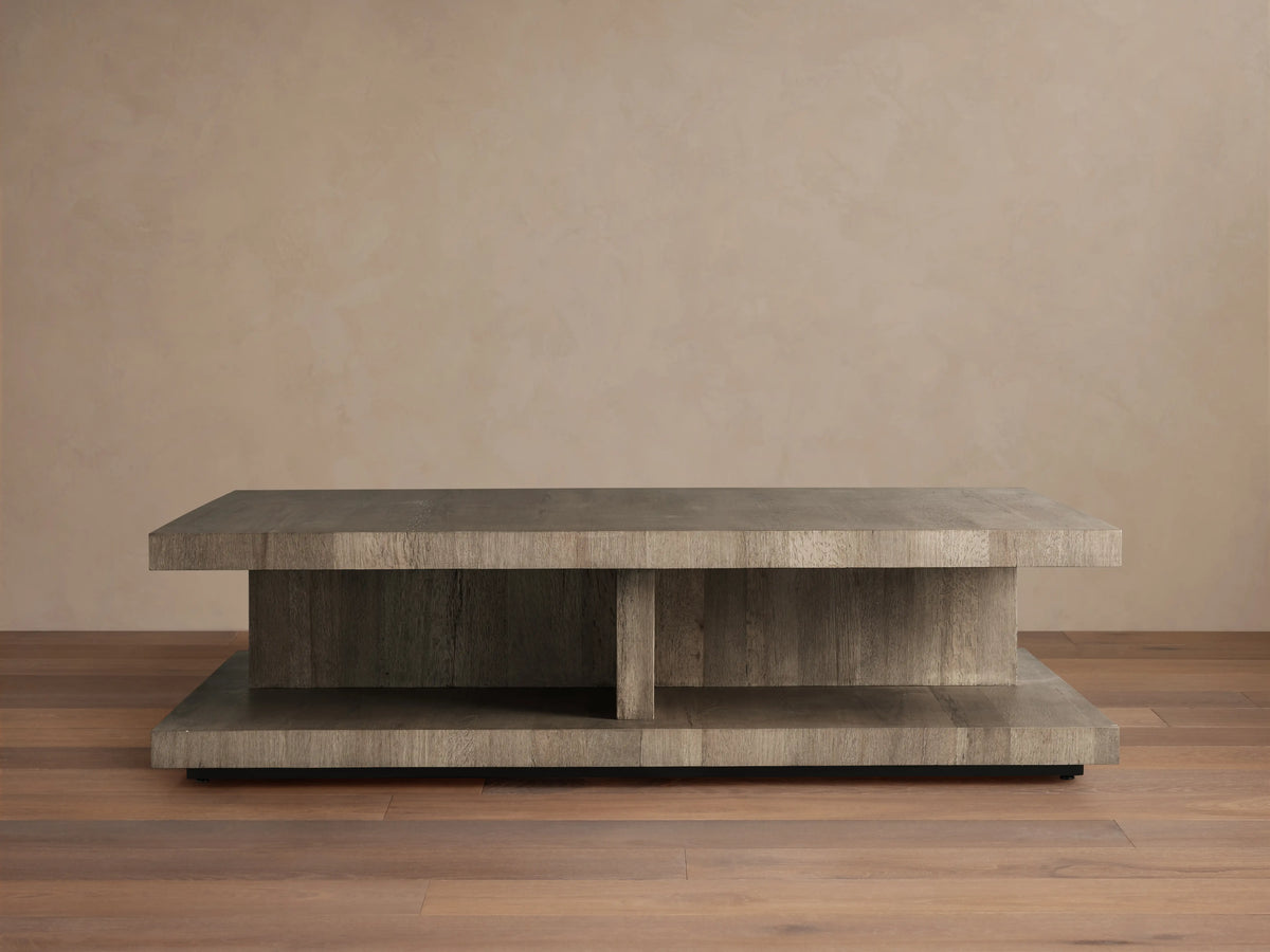 Leandro Coffee Table made of reclaimed wood, with a thick rectangular top, subtle grain, and smooth finish on wooden flooring backdrop.
