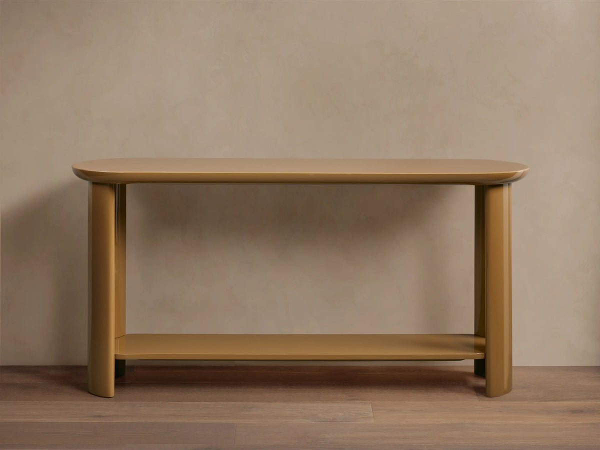 Front view of the golden Lonny Console Table, featuring a high-gloss lacquer finish and a floating lower shelf design.