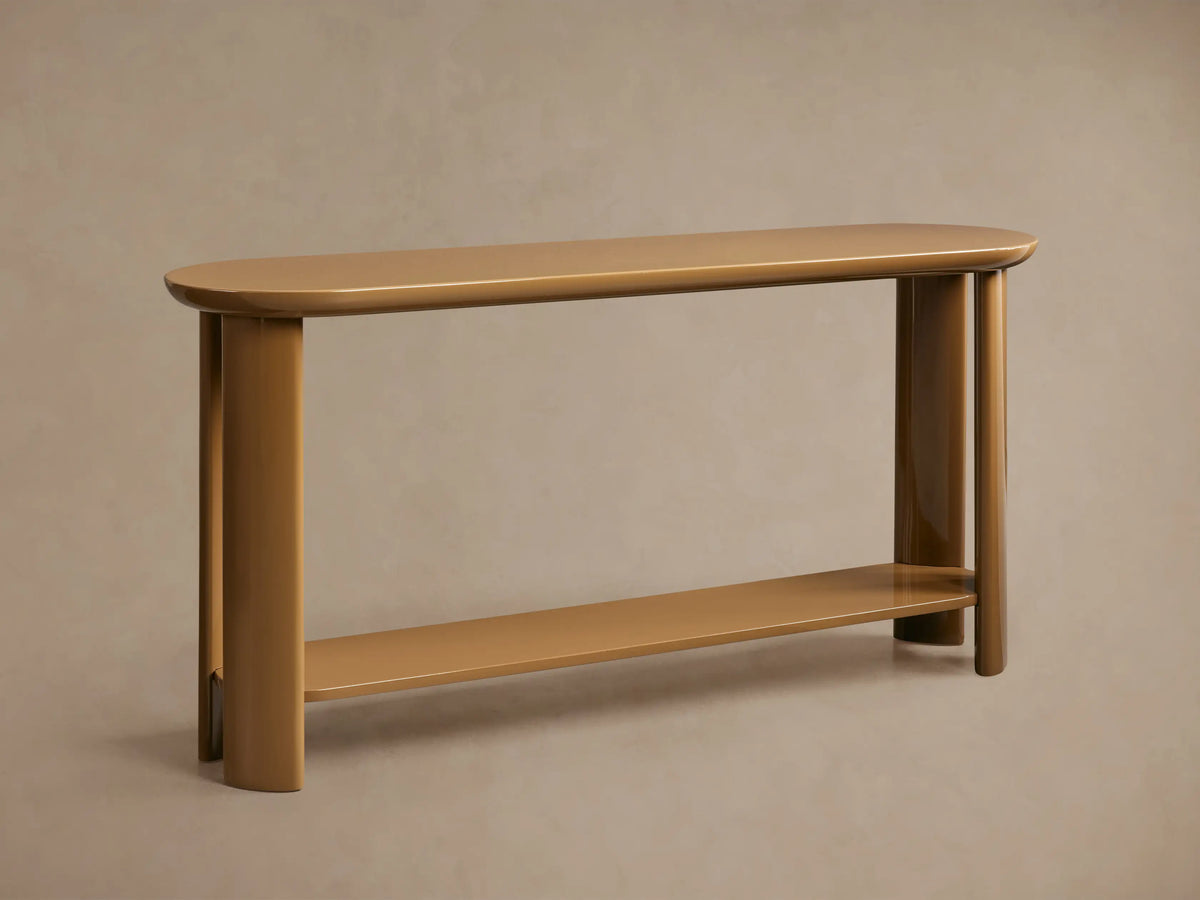 Angled close-up of Lonny Console Table. High-gloss caramel finish, reflecting light on rounded top and floating lower shelf.