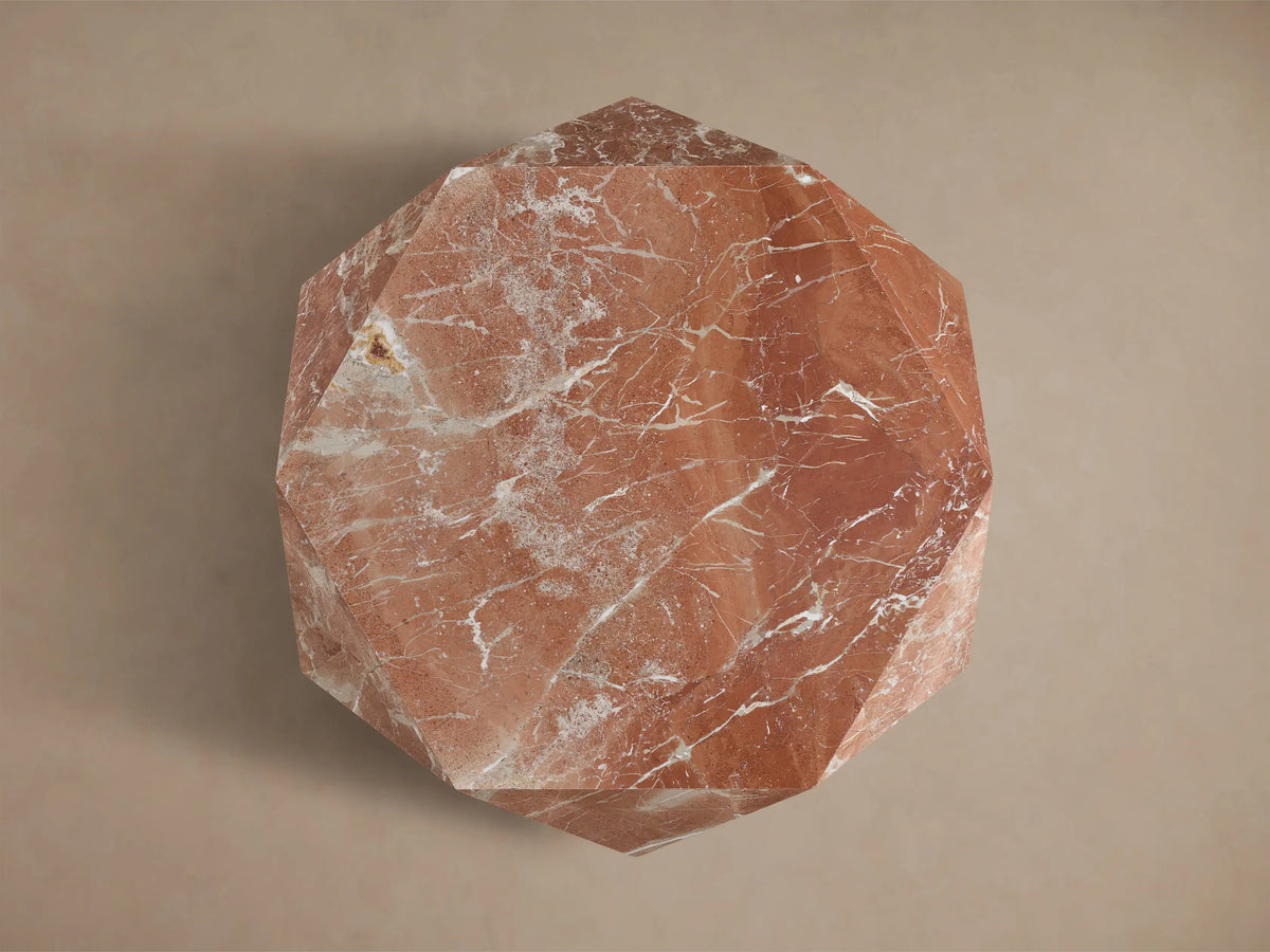 Top view of a faceted reddish-brown marble sculptural piece with white veining, resembling a multi-sided geometric stone.
