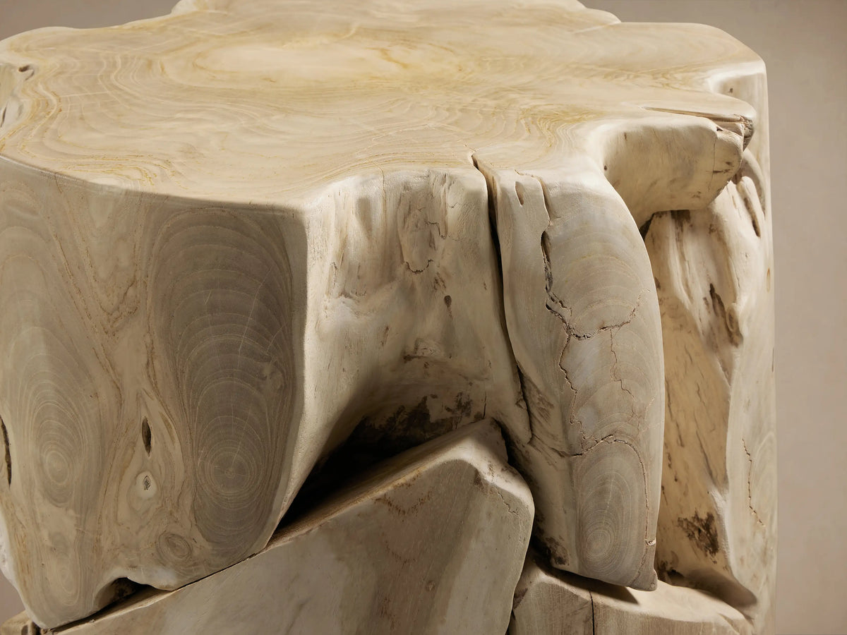 Maggie Stool made of natural wood, featuring a unique, irregular texture with visible grain and rough-hewn edges on a wooden floor.