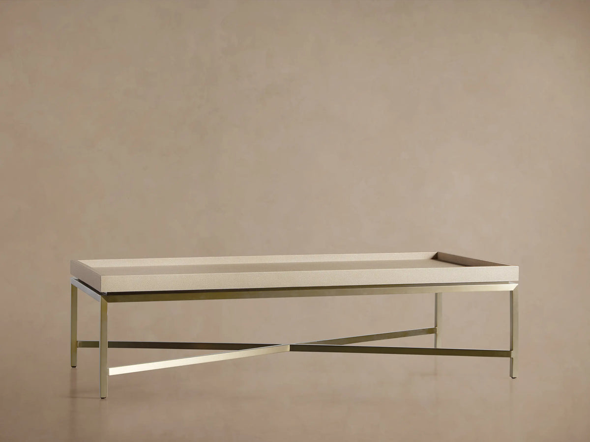 Malone Coffee Table, close-up of corner. Beige shagreen leather tabletop with raised edge and brass-toned steel frame.