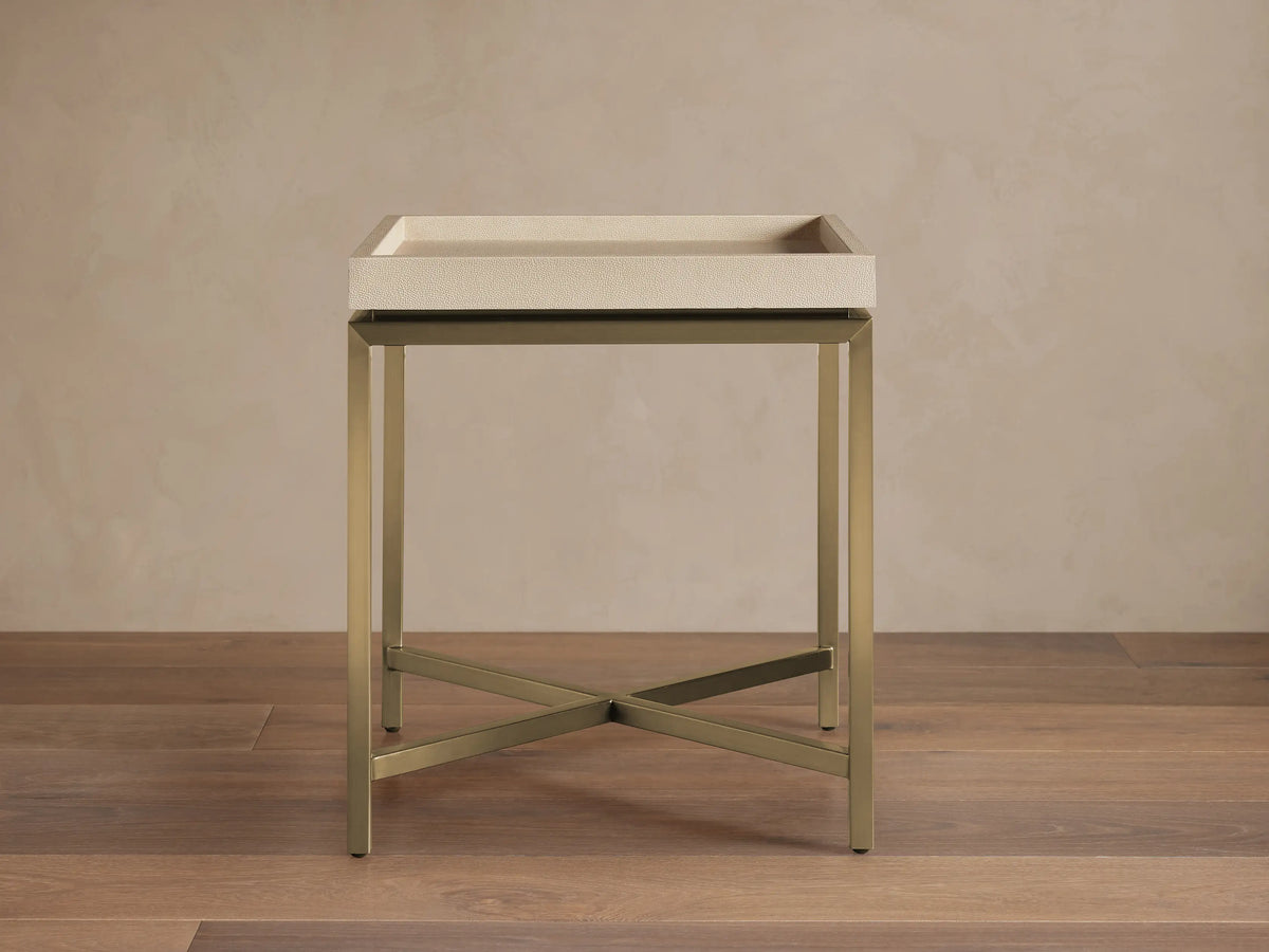 Malone End Table with a beige shagreen-patterned tray top and a metallic gold X-stretcher base, viewed straight on in a room.