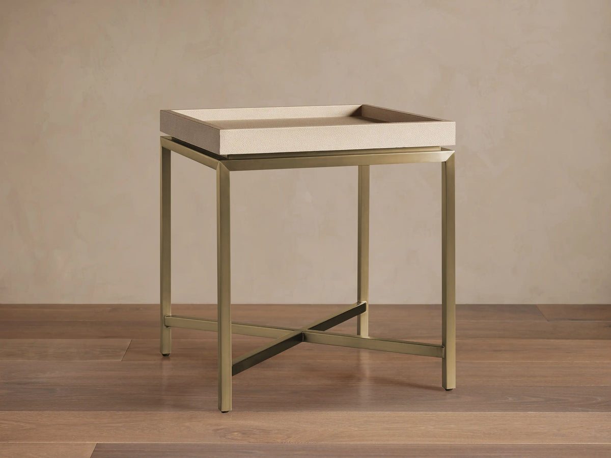 Malone End Table with a beige shagreen-patterned tray top and a metallic gold X-stretcher base, viewed straight on in a room.