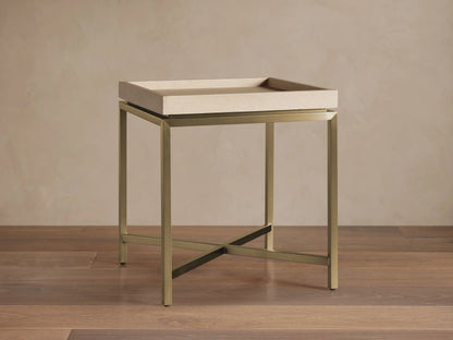 Malone End Table with a beige shagreen-patterned tray top and a metallic gold X-stretcher base, viewed straight on in a room.