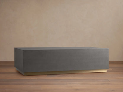 Malone Plinth Coffee Table with a rectangular shape, gray shagreen-patterned top, and a subtle brass-finished base on wooden floor.