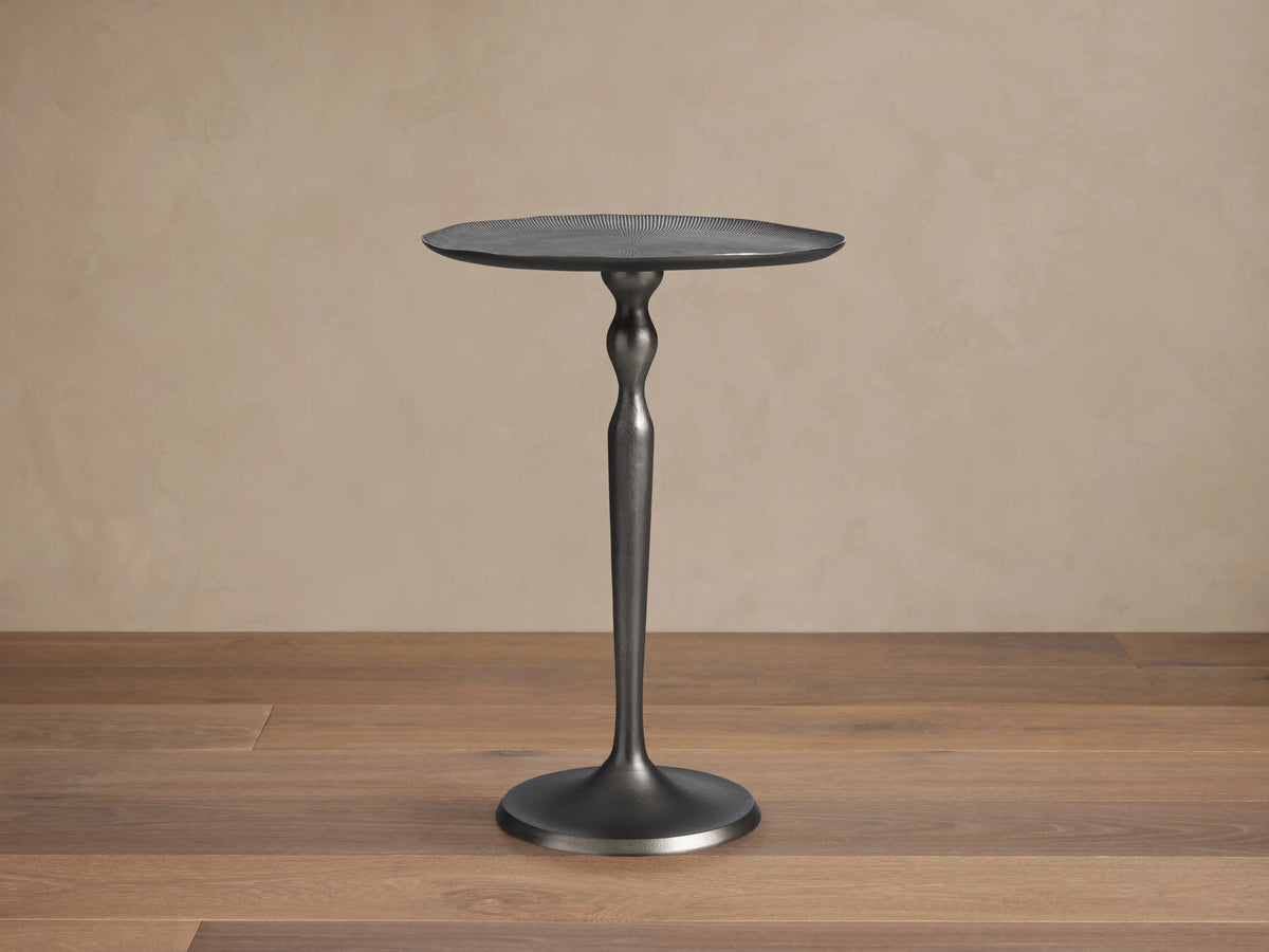 Manhattan Martini Table with a slim, elegant cast aluminum base and a round, textured tabletop, finished in dark zinc.
