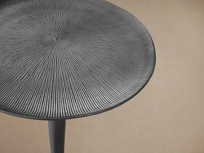 Manhattan Martini Table with a slim, elegant cast aluminum base and a round, textured tabletop, finished in dark zinc.