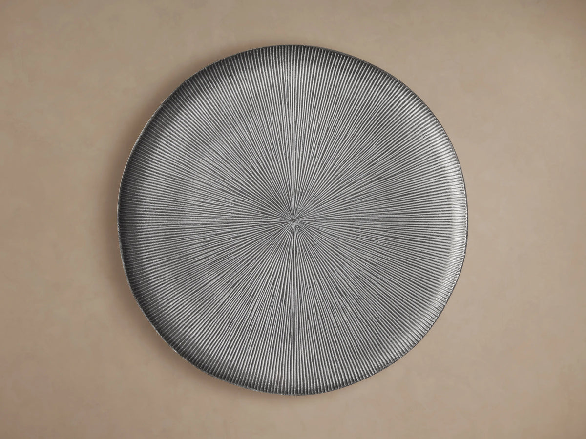 Manhattan Martini Table with a textured, black tabletop featuring radiating grooves, supported by a sleek, dark base on a neutral background.