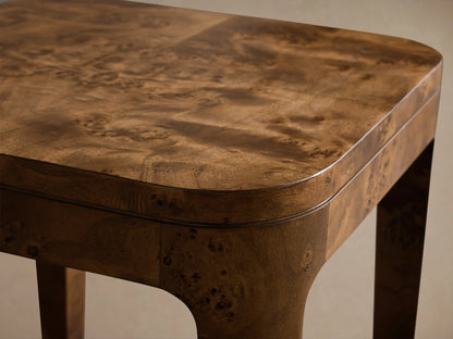 Close-up of the brown mappa burl veneer on the top and rounded edge of the Mogadore End Table, featuring swirling wood grain.
