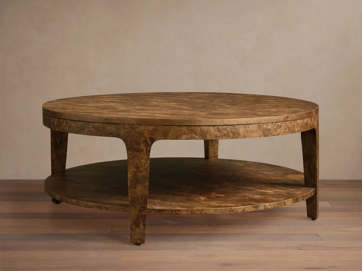 Front view of the Mogadore Round Coffee Table, a golden-brown two-tiered design with swirling mappa burl wood veneer.