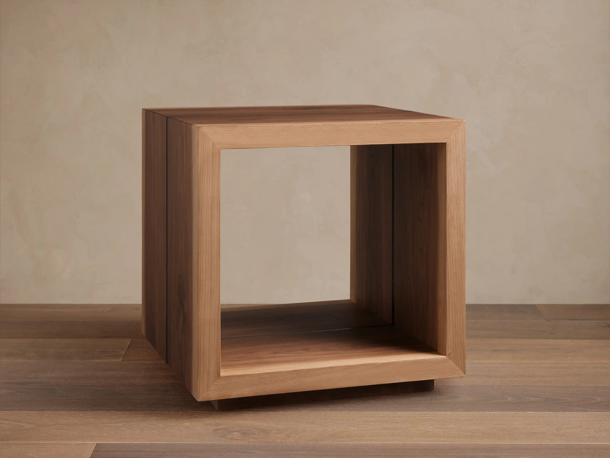 Mihaela End Table, cube-shaped, made from Romanian oak with visible wood grain; open design with smooth finish, on wooden floor.