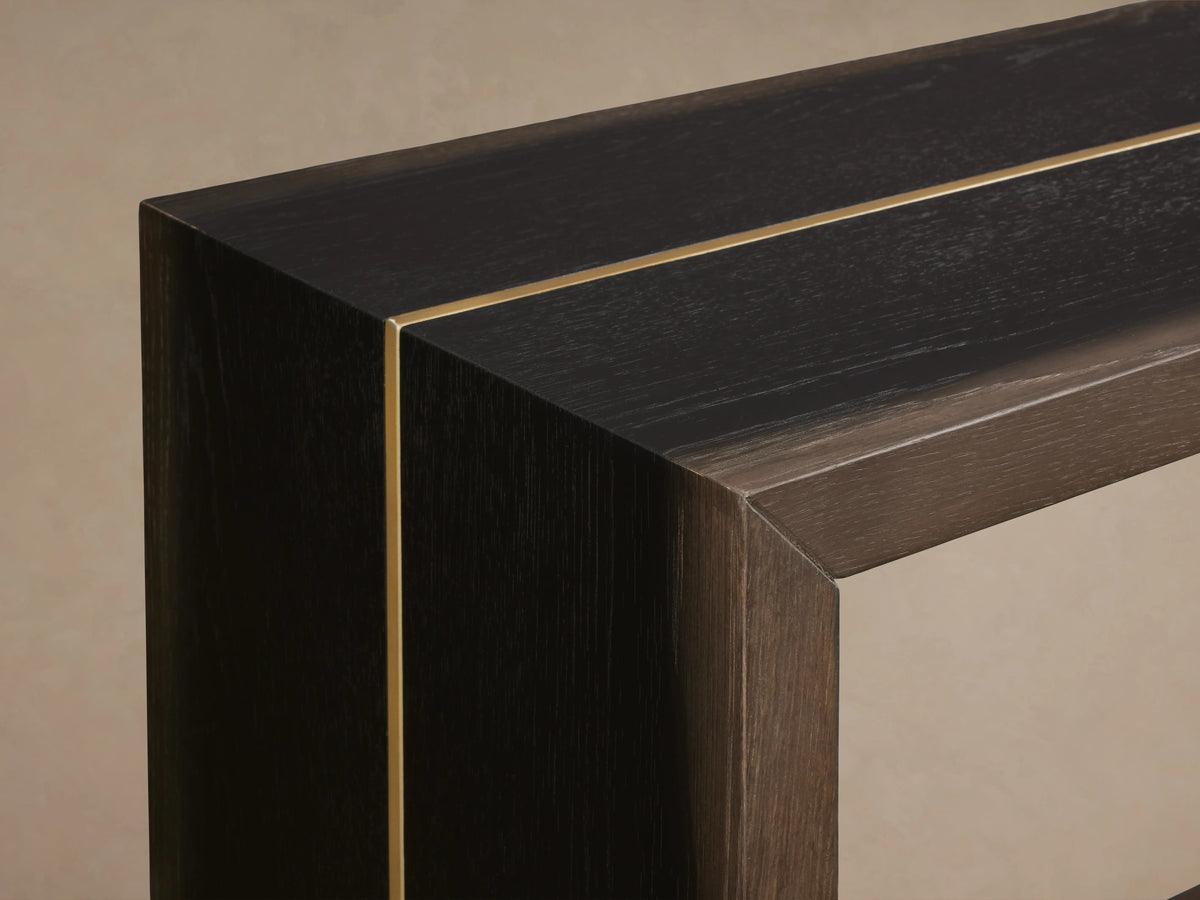 Mihaela Console Table corner detail in dark wood finish with subtle grain, featuring a metallic brass-like line accent.