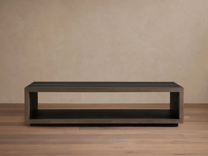 Mihaela Coffee Table in solid wood with a rectangular open-frame design, dark finish, and metallic-like accents on a wooden floor.