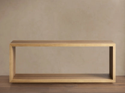 Mihaela Console Table in Vin Alb, rectangular, light wood finish, open frame design on wooden floor against beige wall.