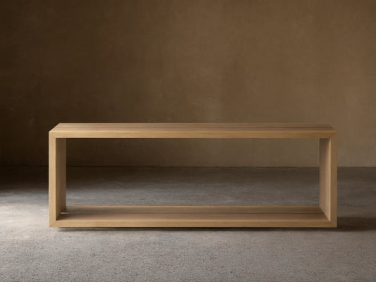 Mihaela Console Table in Vin Alb, rectangular, light wood finish, open frame design on wooden floor against beige wall.