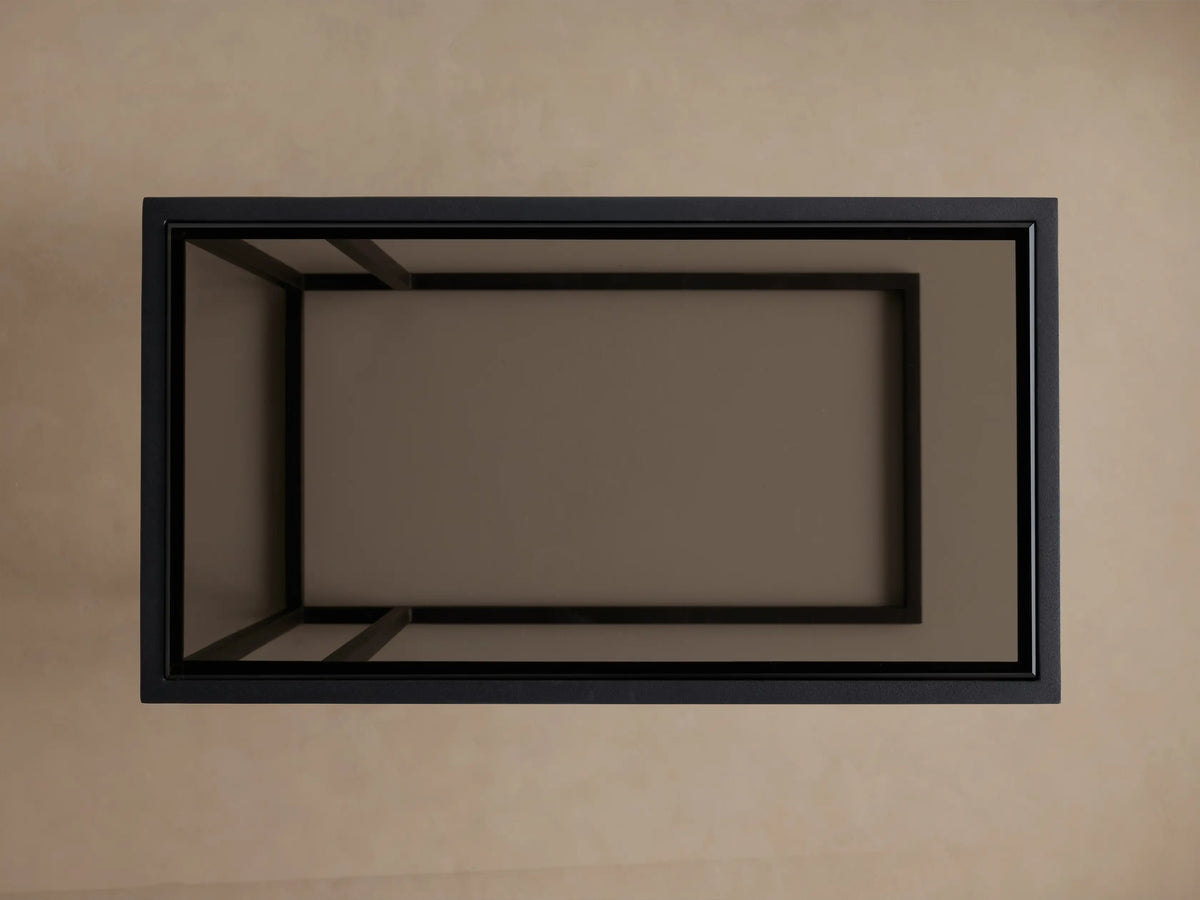 Top-down view of a rectangular Mills Glass C Table with matte black steel frame and dark glass top on a light brown background.