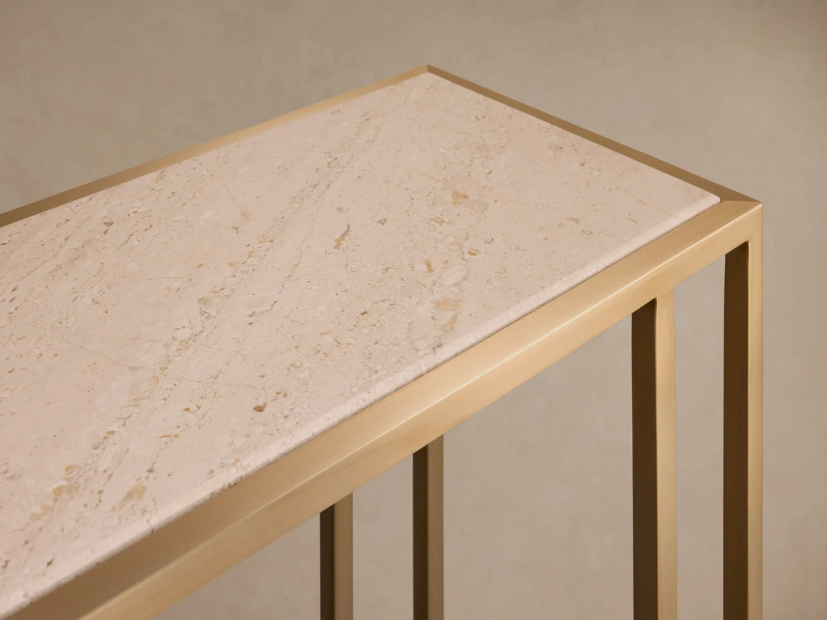 Close-up of the Mills Stone Console Table, featuring its light beige stone top with natural veining and antique brass frame.