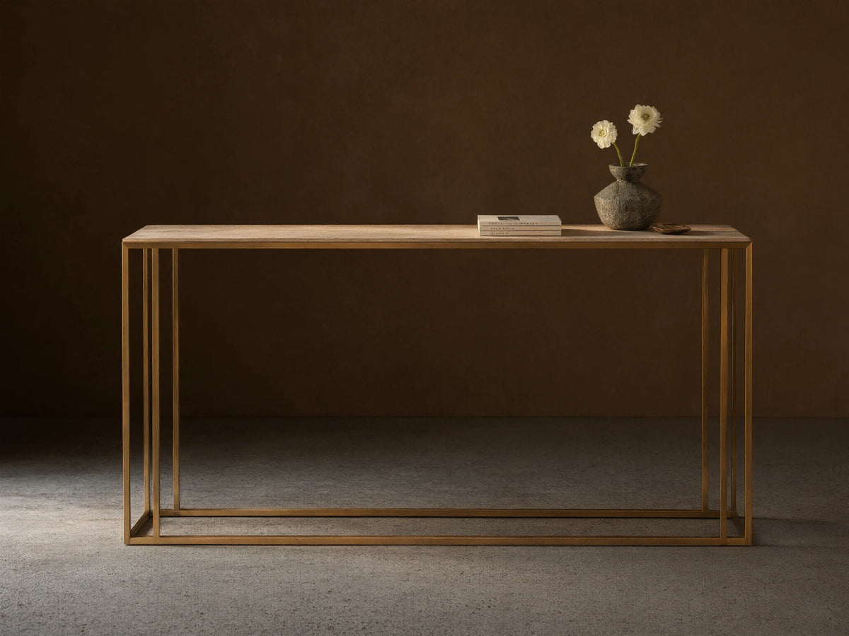 Front view of the Mills Stone Console Table with a light stone top and antique brass frame, decorated with a vase and flowers.