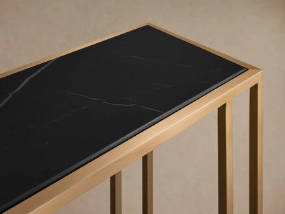 Full view of the Mills Stone Console Table with an antique brass steel base and black stone top, decorated with a candle and vase.
