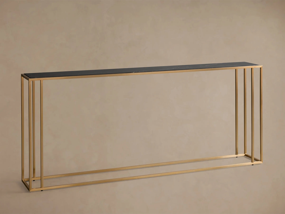 Close-up, angled view of the Mills Stone Console Table, featuring a black stone top with white veining and an antique brass frame.