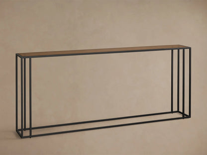 Front view of the long, narrow Mills Glass Console Table with an antique brass-toned glass top and matte black steel frame.