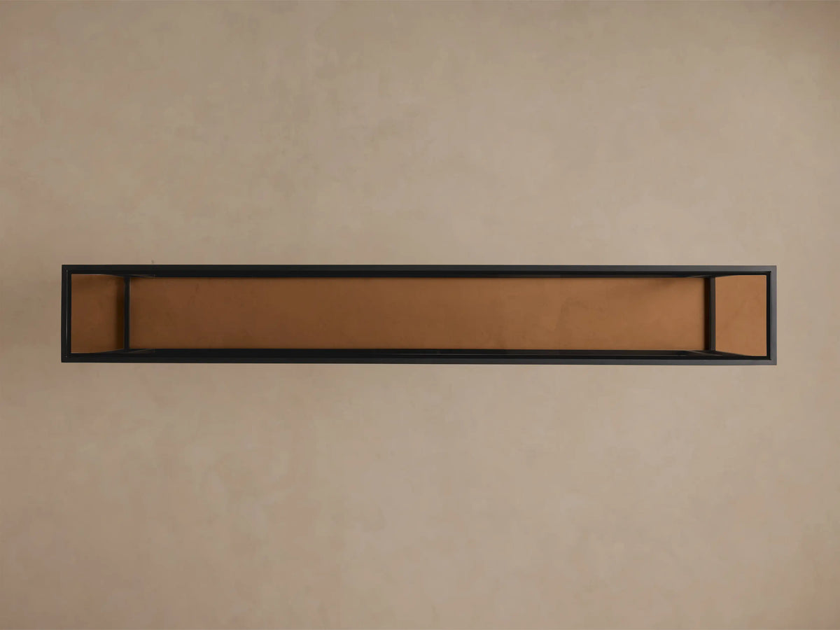 Overhead view of the Mills Glass Console Table. Long black steel frame with an antique brass-toned glass top.