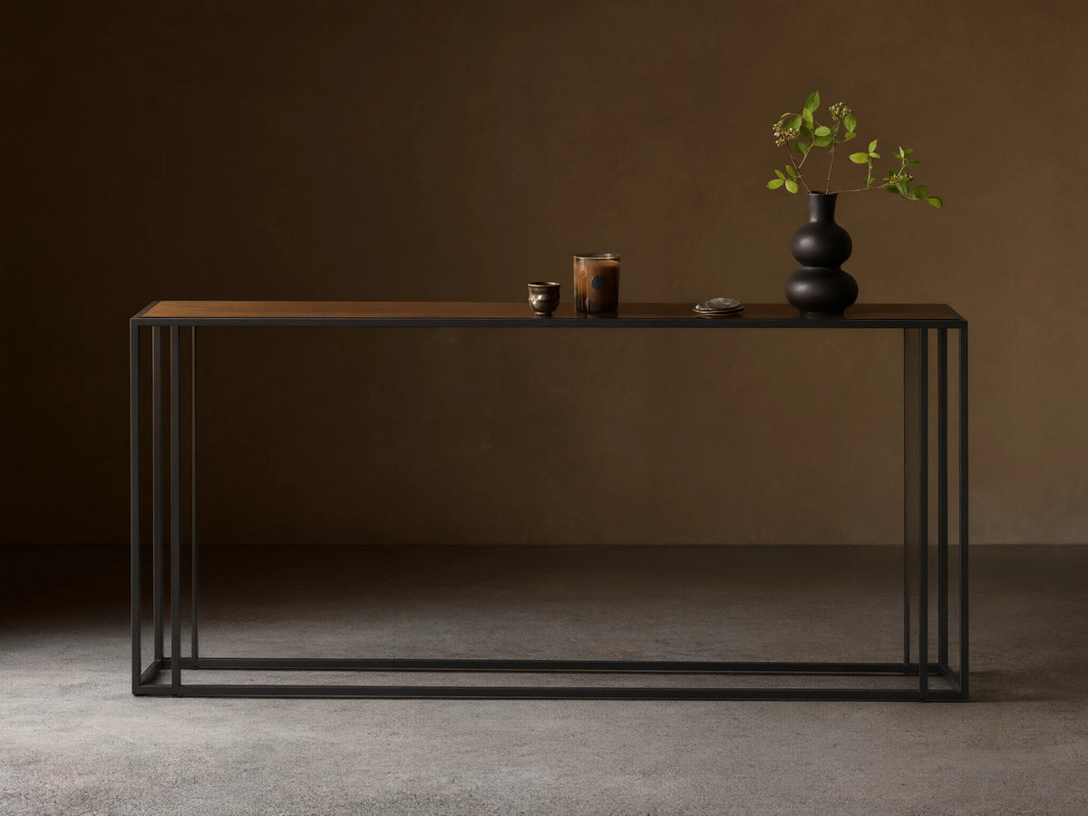 Front view of the long, rectangular Mills Glass Console Table with a clear glass top and matte black steel frame.