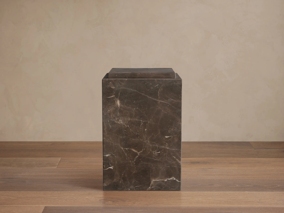 Handcrafted Marmont Pedestal made of natural dark marble with unique veining, matte lacquer finish, on a wooden floor.
