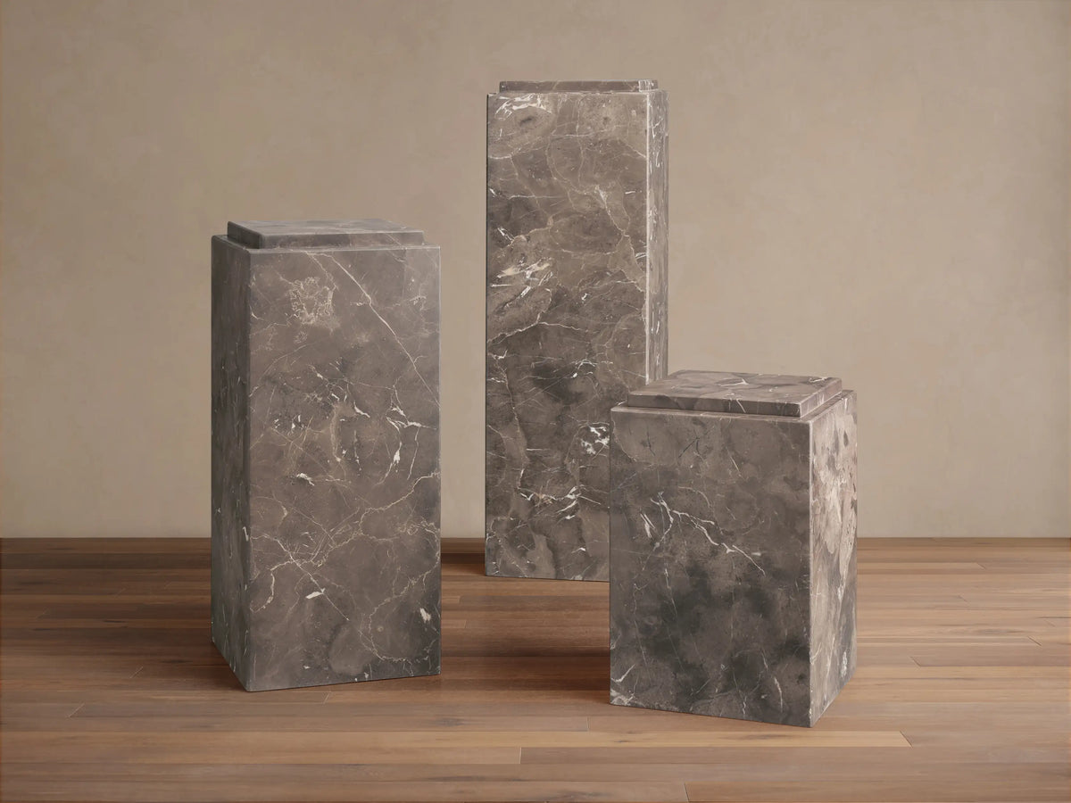 A square Marmont Pedestal made of natural marble with dark brown veining and a hand-applied matte finish, showcasing unique patterns.