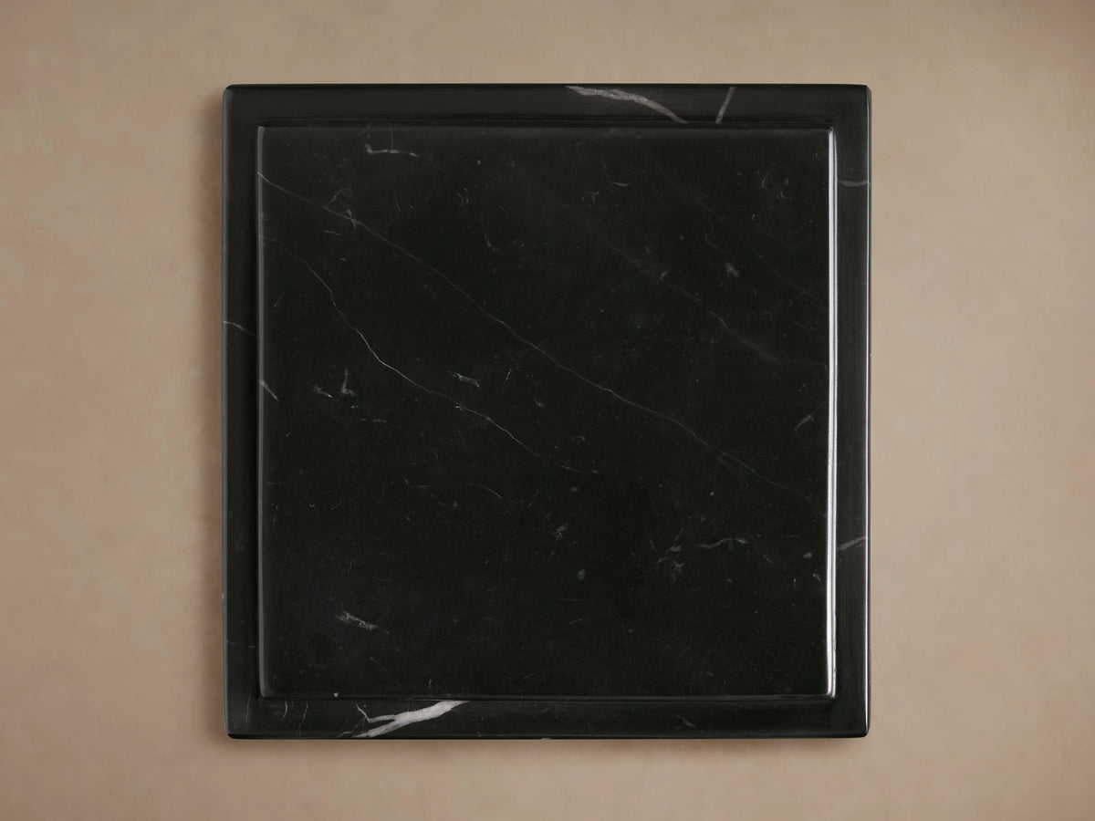 Three black marble Marmont Pedestals of varying heights, featuring striking white veining, on a wood floor.