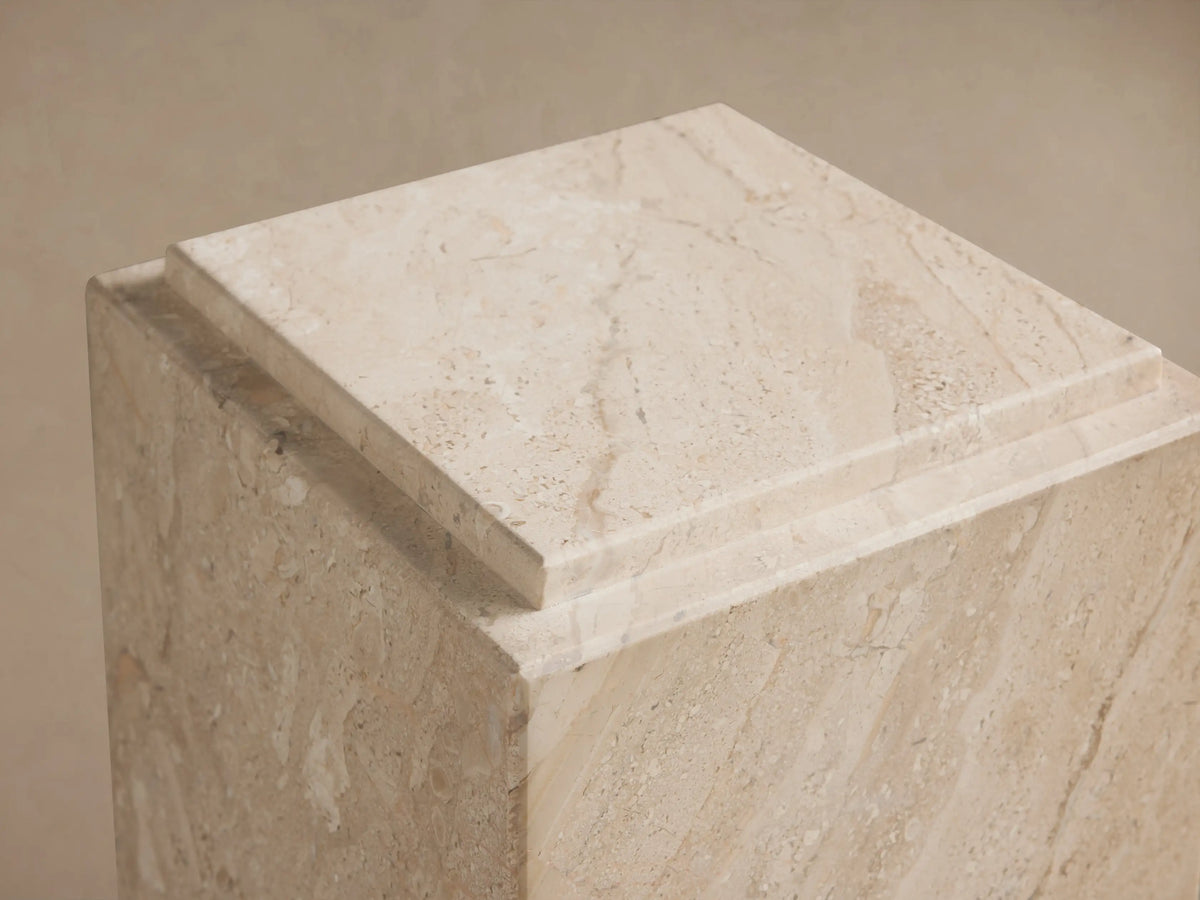 Marmont Pedestal featuring natural marble with beige veining, rectangular shape, matte finish, set on wooden floor against a neutral wall.