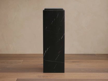 Light gray veined Marmont Pedestal, a round stone side table with a cylindrical pedestal base, visible through open doors.