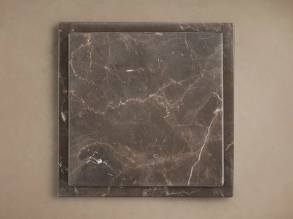 Three Marmont Pedestals of varying heights, dark gray natural marble with white veining, on a wood floor.