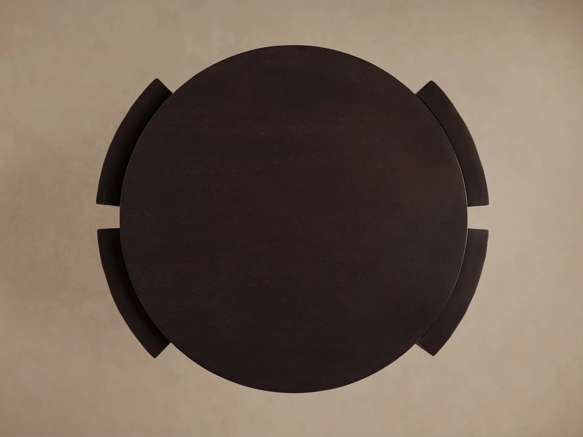 Dark, round mahogany Chiseled End Table, top-down view, showing its circular top and curved, wrap-around legs.