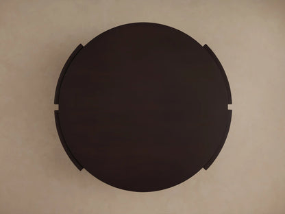 Dark brown mahogany Chiseled Round Coffee Table, showing the round top, lower shelf, and hand-carved textured sides.